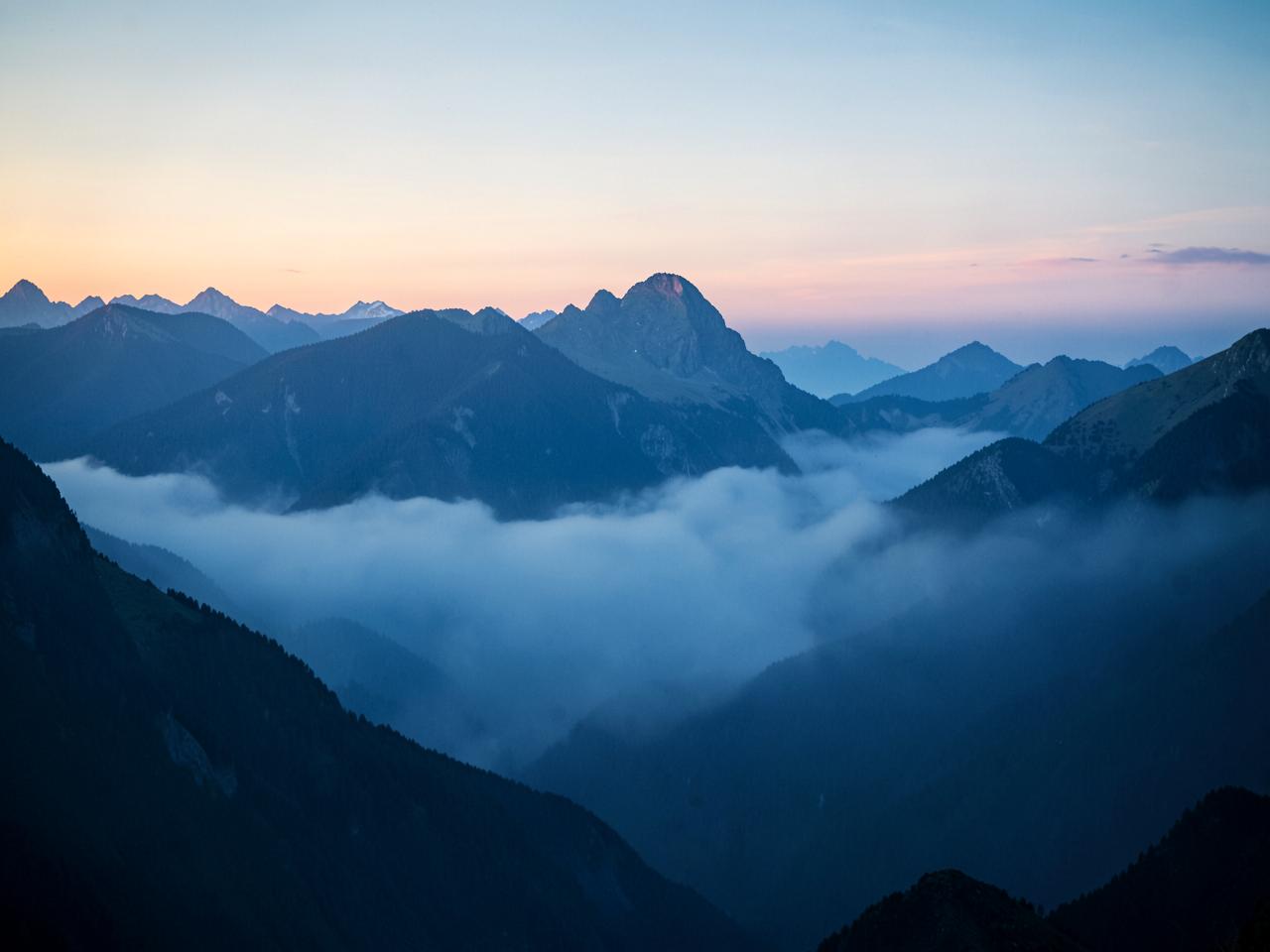 Mist settling between mountain ridges at first light